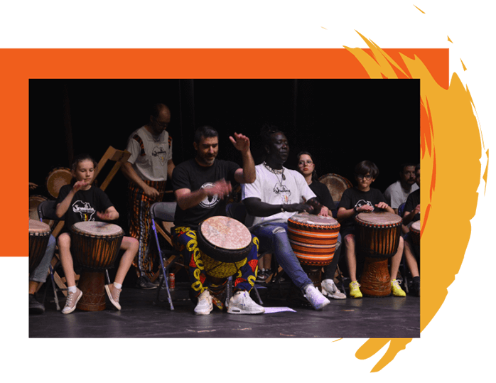 Jerôme le fondateur de l'association Soundiata joue du djembé sur scène avec les élèves adultes et enfants du cours de percussions mandingues